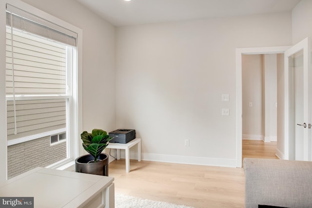office space with baseboards and light wood finished floors