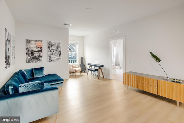 living area with light wood-type flooring and visible vents