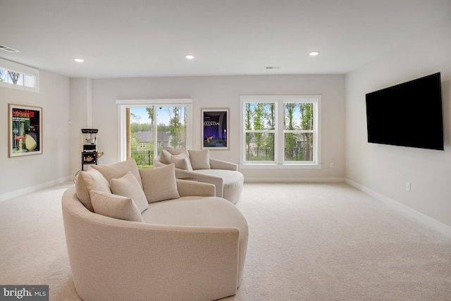 living area featuring baseboards, plenty of natural light, carpet flooring, and recessed lighting