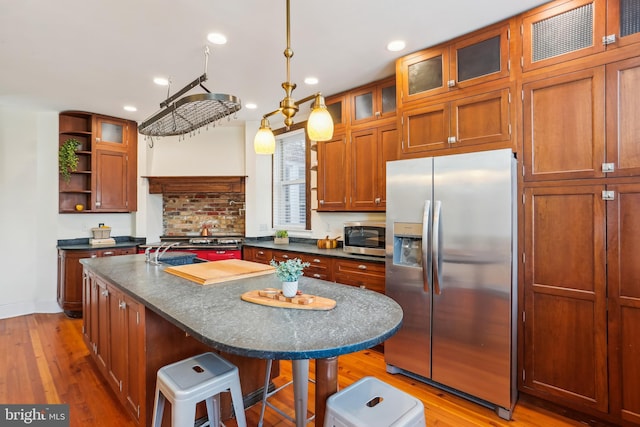 1231 Girard St NW, Washington, DC 20009 - kitchen featuring stainless steel appliances, light wood-style flooring, open shelves, and dark countertops