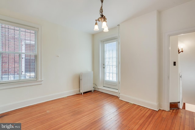 1231 Girard St NW, Washington, DC 20009 - empty room with a chandelier, light wood-type flooring, baseboards, and radiator