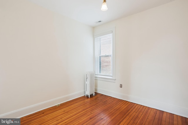 1231 Girard St NW, Washington, DC 20009 - spare room with light wood finished floors, radiator heating unit, baseboards, and visible vents