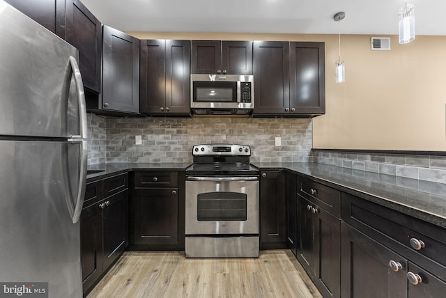 kitchen with tasteful backsplash, visible vents, light wood-type flooring, and appliances with stainless steel finishes