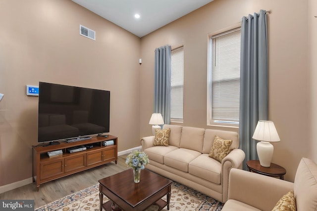 living area featuring visible vents, baseboards, light wood-type flooring, and recessed lighting