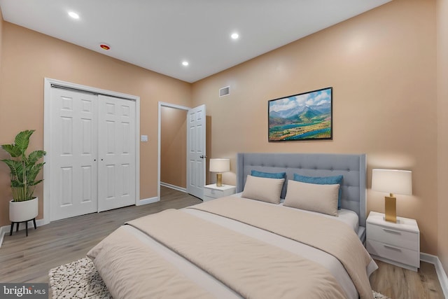 bedroom with a closet, light wood-type flooring, baseboards, recessed lighting, and visible vents