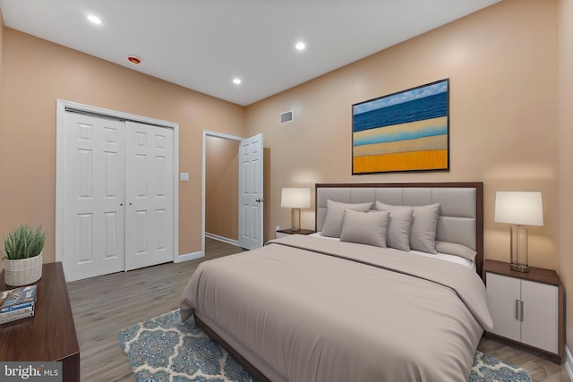 bedroom with wood finished floors, baseboards, a closet, and recessed lighting