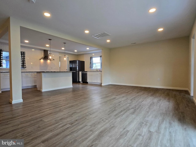 unfurnished living room featuring dark wood-style flooring, a sink, visible vents, and recessed lighting