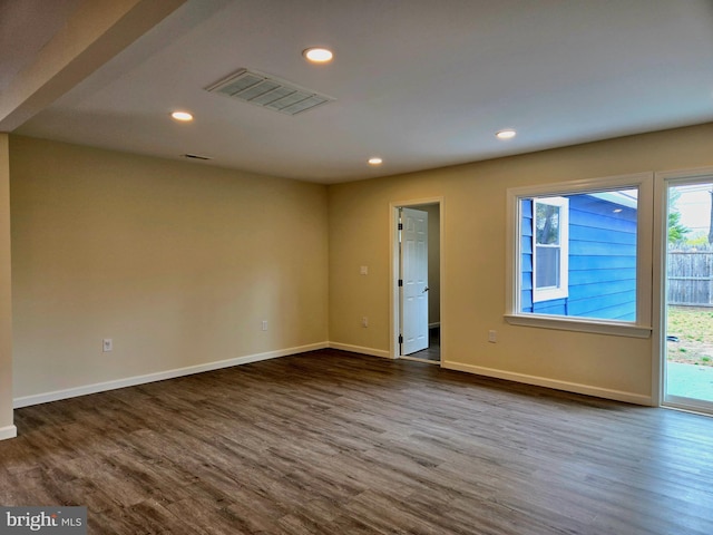 unfurnished room featuring recessed lighting, dark wood-type flooring, visible vents, and baseboards