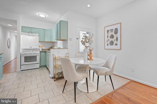 1773 Swann St NW, Washington, DC 20009 - kitchen with white range with gas stovetop, under cabinet range hood, green cabinets, and light countertops