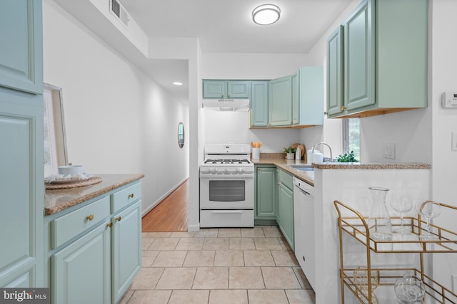 1773 Swann St NW, Washington, DC 20009 - kitchen with white appliances, under cabinet range hood, light tile patterned floors, and light countertops