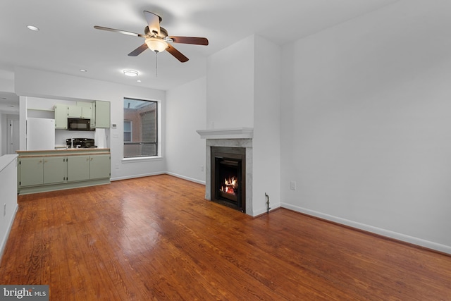1773 Swann St NW, Washington, DC 20009 - unfurnished living room featuring a ceiling fan, wood finished floors, a lit fireplace, and recessed lighting