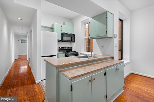 1773 Swann St NW, Washington, DC 20009 - kitchen featuring black appliances, light wood-style floors, a peninsula, light countertops, and recessed lighting