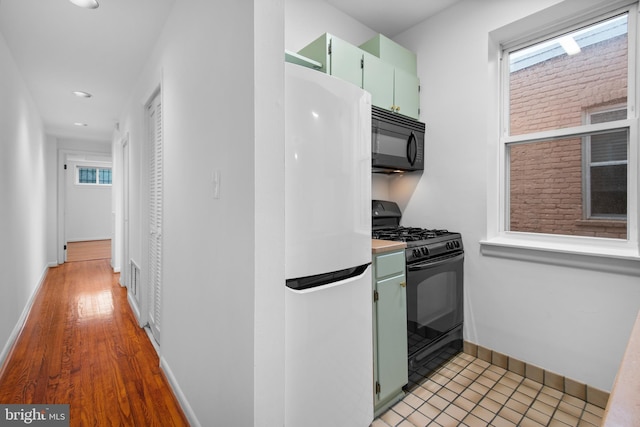 1773 Swann St NW, Washington, DC 20009 - kitchen with black appliances, green cabinets, plenty of natural light, recessed lighting, and light countertops
