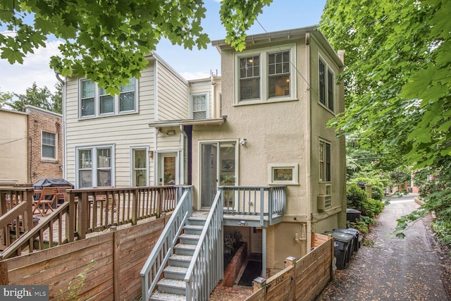back of property featuring stairs, a wooden deck, and cooling unit
