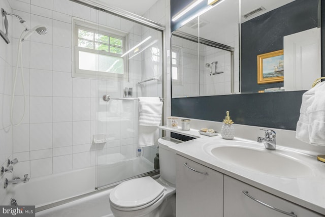 full bathroom featuring toilet, vanity, and bath / shower combo with glass door
