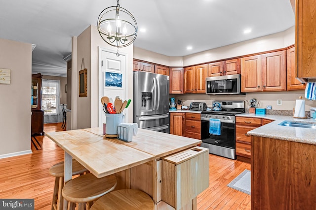 kitchen with light wood-type flooring, a sink, stainless steel appliances, brown cabinets, and a notable chandelier