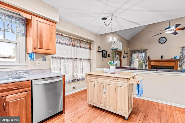kitchen featuring open floor plan, light countertops, light wood-style floors, lofted ceiling, and dishwasher