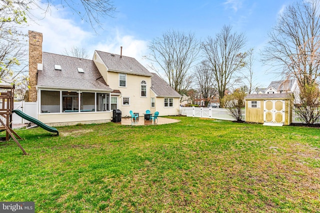 back of property with a shed, a sunroom, a fenced backyard, an outdoor structure, and a playground