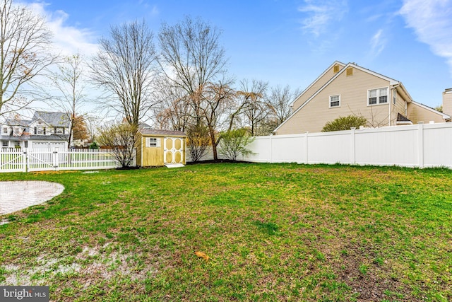 view of yard featuring a shed, a fenced backyard, an outdoor structure, and a gate