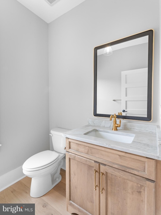 bathroom featuring toilet, wood finished floors, vanity, and visible vents