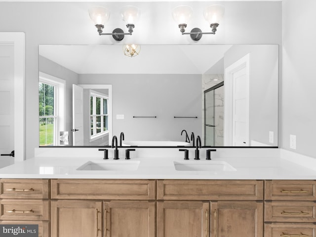 full bathroom with double vanity, a sink, and a stall shower