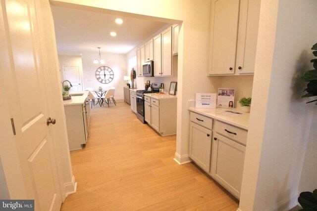 1609 Schwinn St, Middletown, DE 19709 - kitchen with stainless steel appliances, light wood-type flooring, recessed lighting, light countertops, and decorative light fixtures