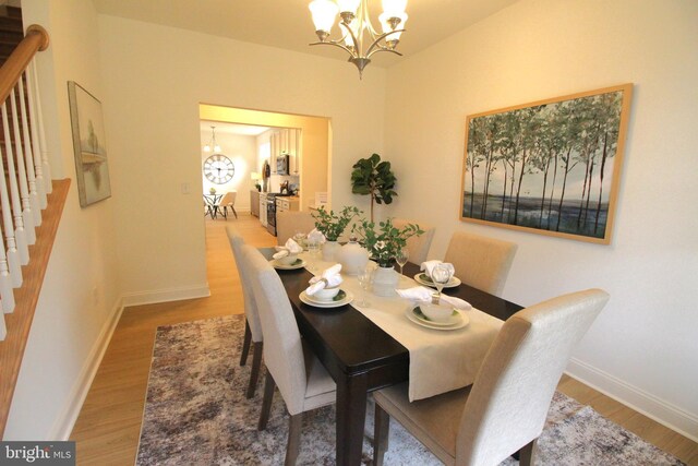 1609 Schwinn St, Middletown, DE 19709 - dining room featuring baseboards, a notable chandelier, stairs, and light wood finished floors