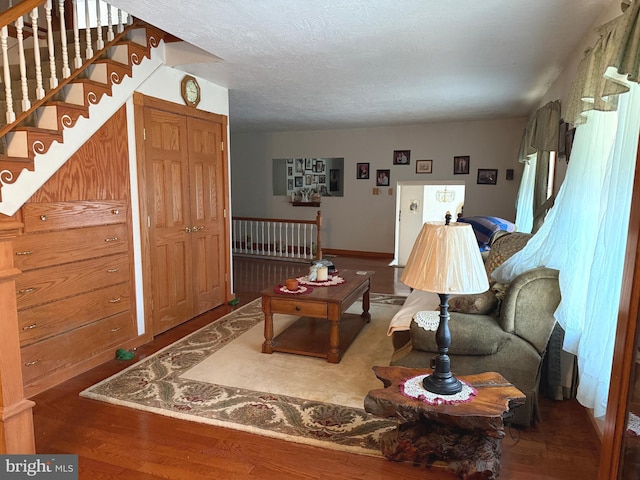 living area with baseboards and wood finished floors