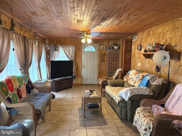 living area with ceiling fan, visible vents, wood walls, light tile patterned floors, and wooden ceiling