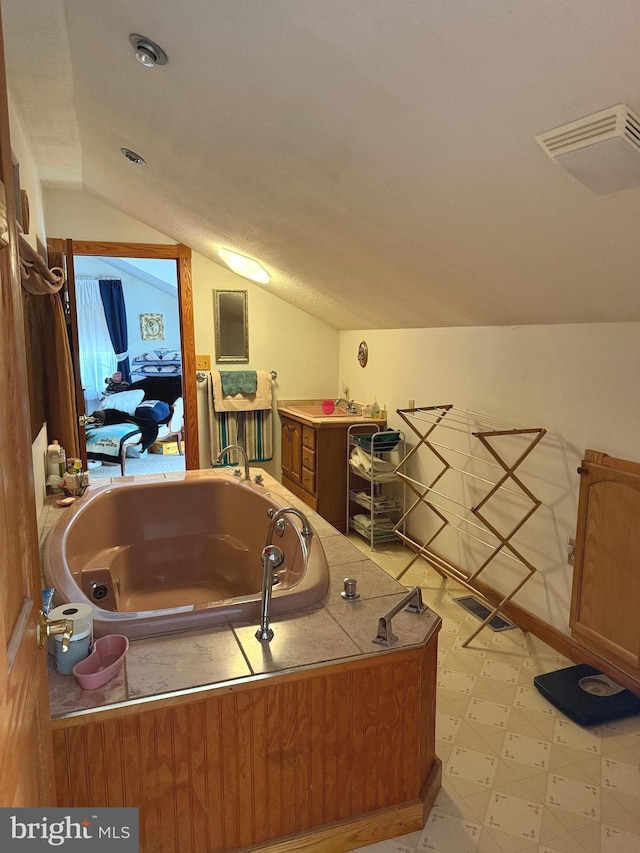 bathroom with tile patterned floors, visible vents, a garden tub, and lofted ceiling