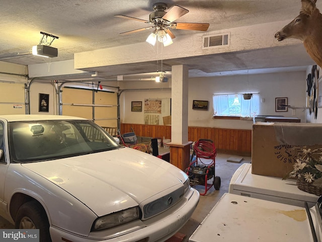garage with visible vents, a garage door opener, and a ceiling fan
