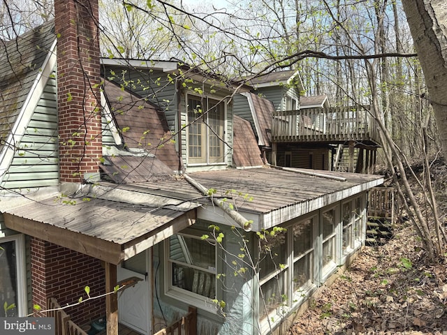 view of home's exterior with a wooden deck and a chimney