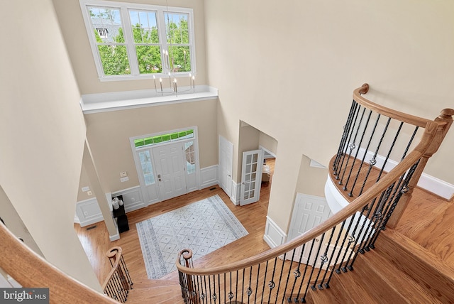 foyer with a high ceiling, stairs, and wood finished floors