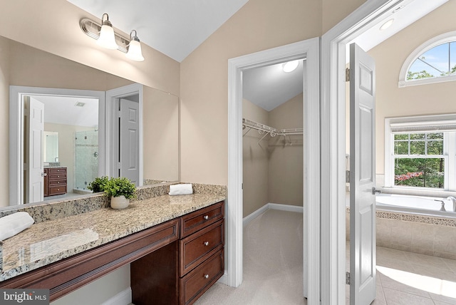 bathroom with vanity, vaulted ceiling, a spacious closet, and a shower stall