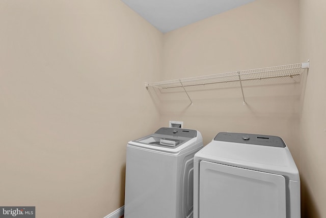 laundry room featuring separate washer and dryer, baseboards, and laundry area