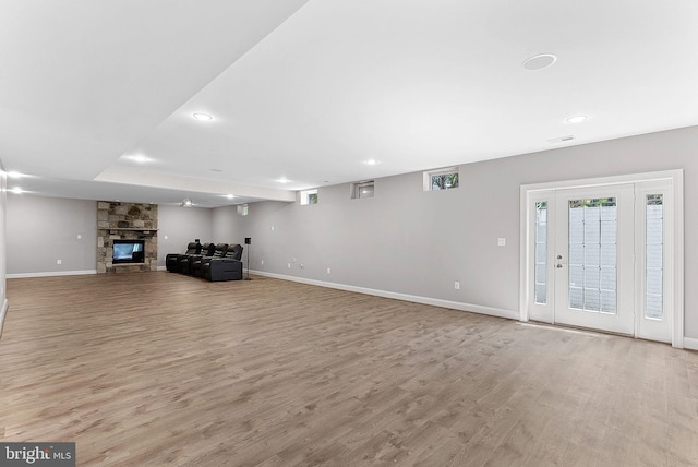 unfurnished living room with recessed lighting, baseboards, wood finished floors, and a fireplace