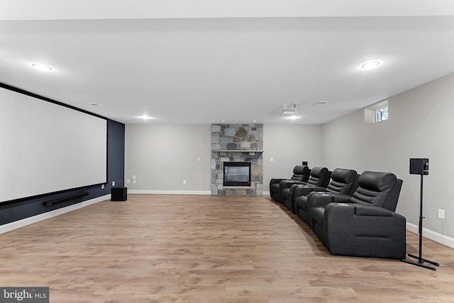 cinema room featuring recessed lighting, baseboards, light wood finished floors, and a fireplace