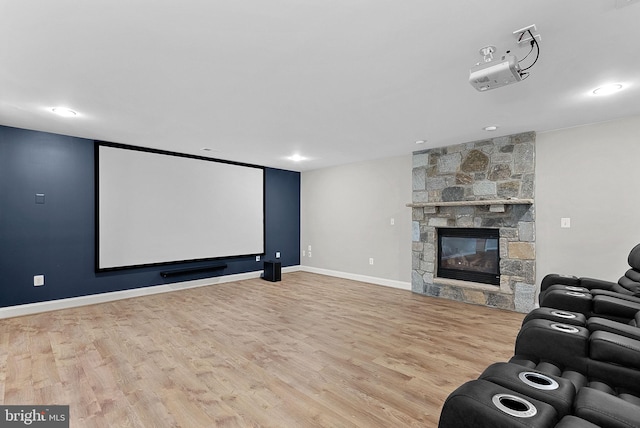 cinema featuring baseboards, a stone fireplace, recessed lighting, and wood finished floors