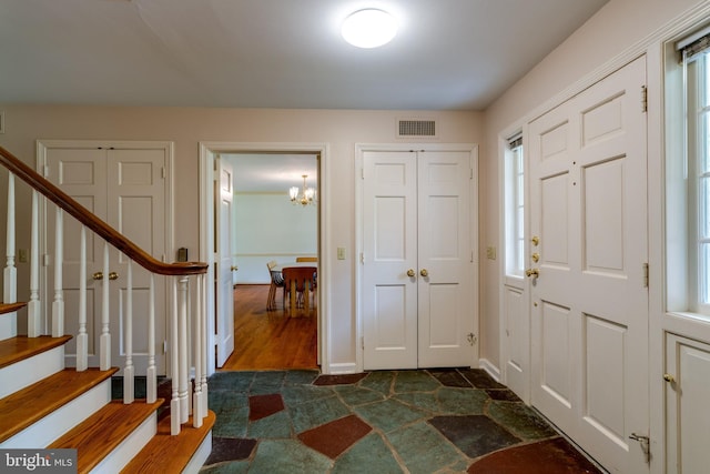 1428 Center Rd, Lancaster, PA 17603 - entrance foyer with a chandelier, dark stone finish floors, stairs, and baseboards