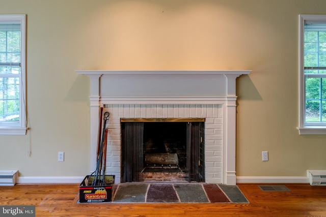 1428 Center Rd, Lancaster, PA 17603 - detailed view of wood finished floors, a brick fireplace, baseboards, and a baseboard radiator