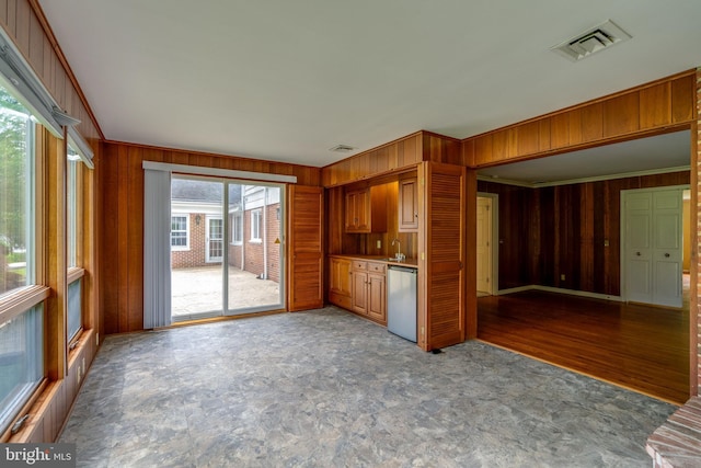 1428 Center Rd, Lancaster, PA 17603 - kitchen with stainless steel dishwasher, wooden walls, ornamental molding, a sink, and brown cabinets