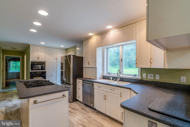 1428 Center Rd, Lancaster, PA 17603 - kitchen featuring black appliances, a sink, dark countertops, a kitchen island, and light wood-type flooring