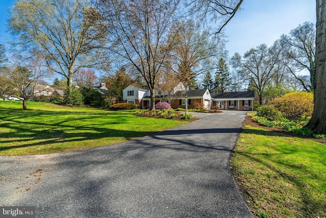 view of front of home with a front lawn and asphalt driveway