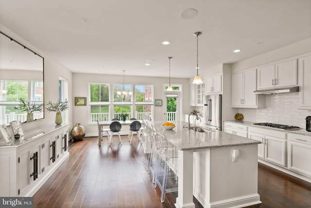 kitchen featuring a wealth of natural light, under cabinet range hood, stainless steel appliances, and a sink