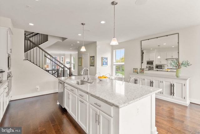 kitchen with dark wood finished floors, white cabinets, appliances with stainless steel finishes, and a sink