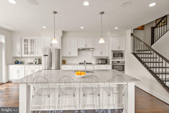kitchen with under cabinet range hood, stainless steel appliances, dark wood-style floors, and recessed lighting