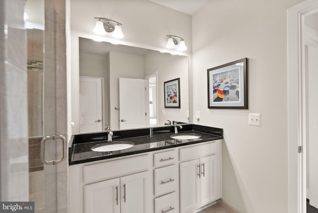 full bath with double vanity, a stall shower, and a sink