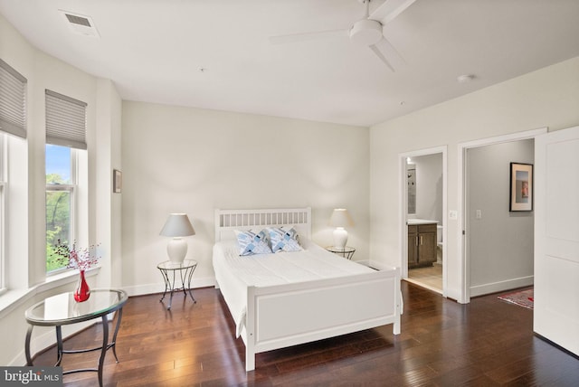 bedroom featuring ensuite bath, baseboards, visible vents, and hardwood / wood-style flooring