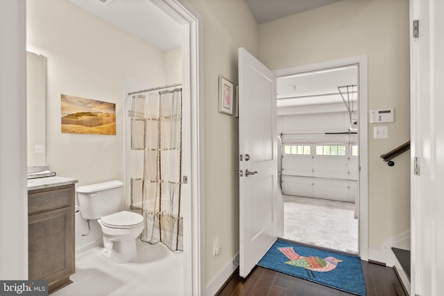 bathroom with wood finished floors, vanity, a shower with curtain, baseboards, and toilet