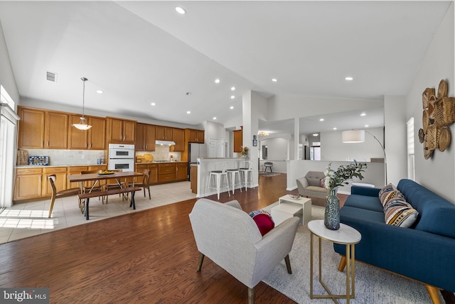 living area featuring visible vents, light wood-style flooring, recessed lighting, and a wealth of natural light